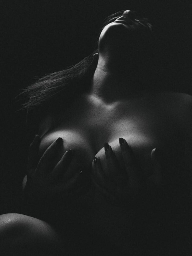 A Dramatic Black And White Artistic Nude Photograph Featuring A Woman In A Sensual Pose.